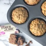 top down view of muffins in muffin tin with fiber bar and crumbs on counter