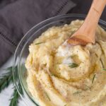 wooden spoon digging into bowl of mashed potatoes