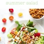 plate with salad topped with chickpeas vegetables and ranch dressing