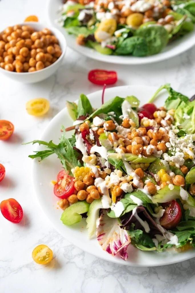 plaes with salad topped with chickpeas and vegetables