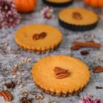 three mini pumpkin pies topped with pecans