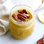small jar filled with pumpkin chia pudding and topped with pecans