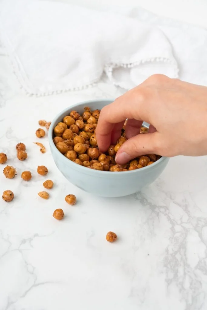 hand reaching into bowl of crispy chickpeas