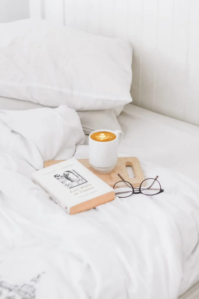 coffee and a book on white sheets