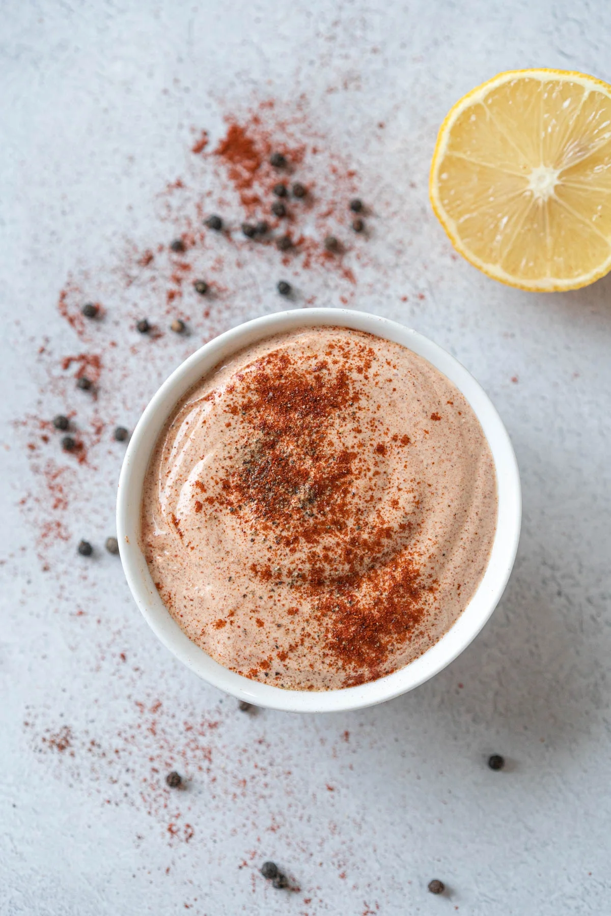 bowl of creamy chili sauce with a lemon in the background