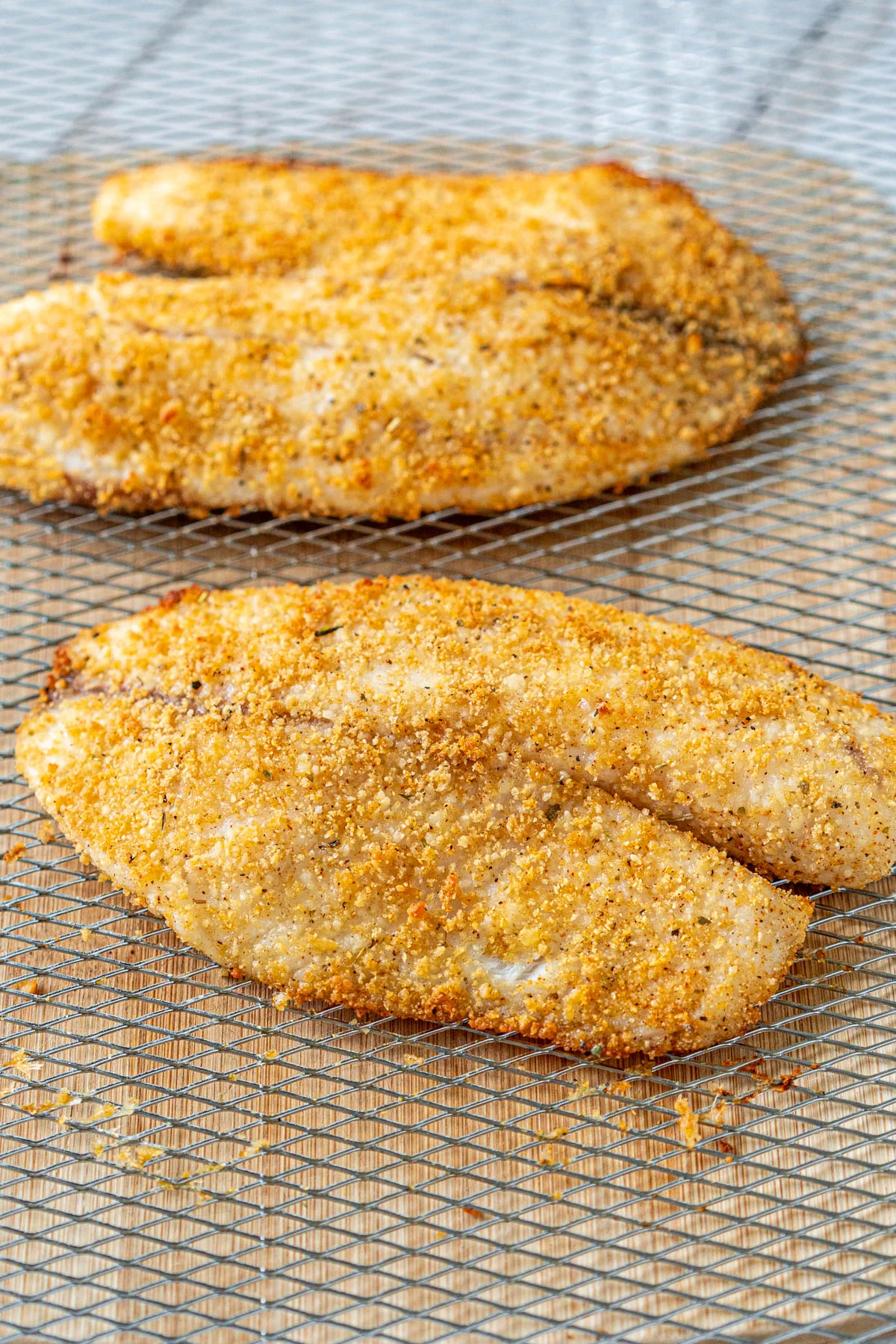 closeup of breaded tilapia in an air fryer basket