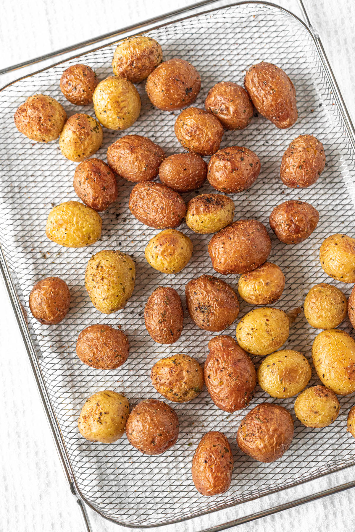 air-fried baby potatoes spread out on an air fryer basket