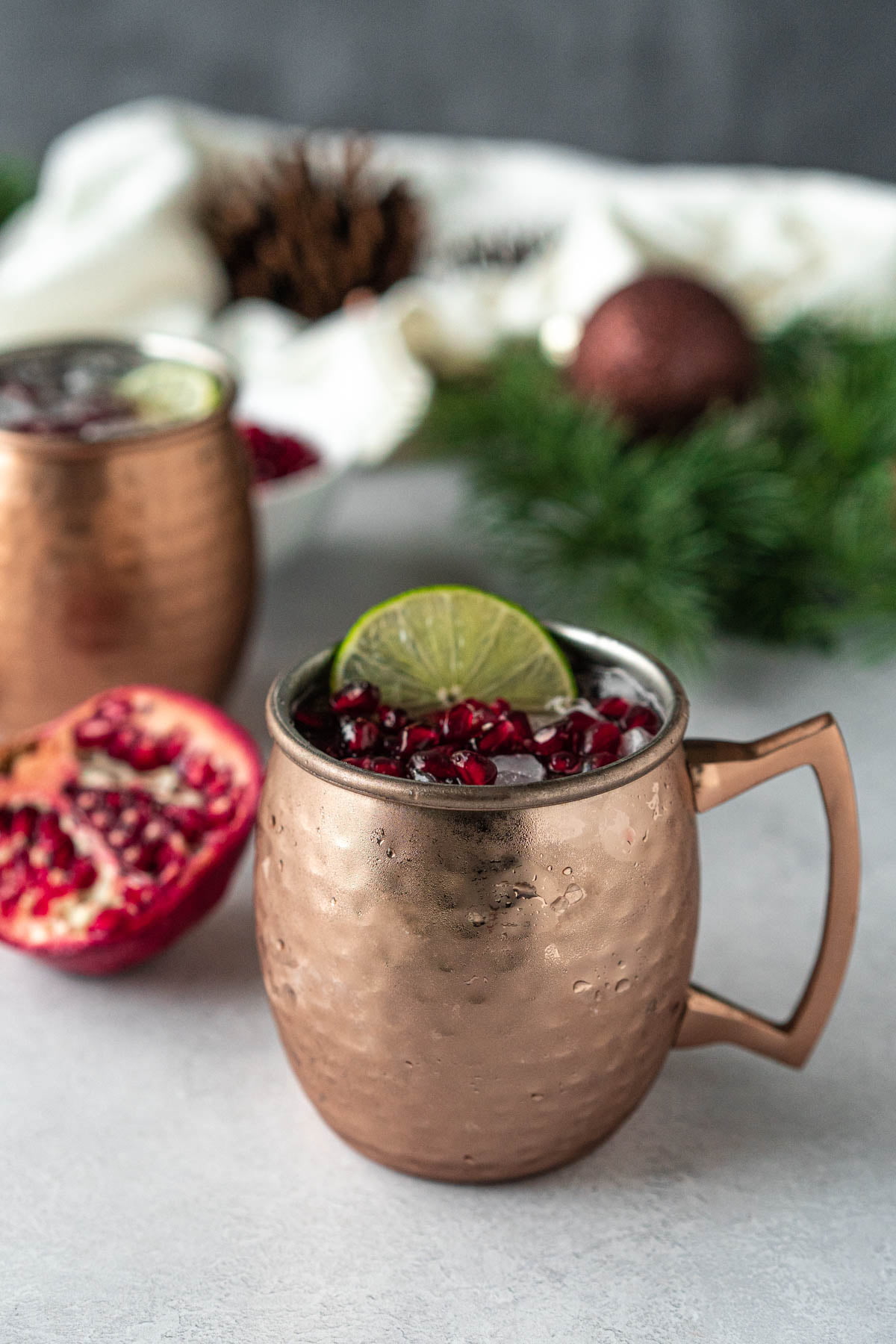 copper mug filled with ice and topped with pomegranate arils and a lime slice