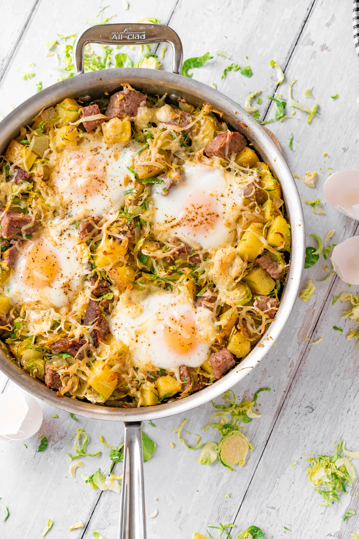 skillet with breakfast hash topped with baked eggs