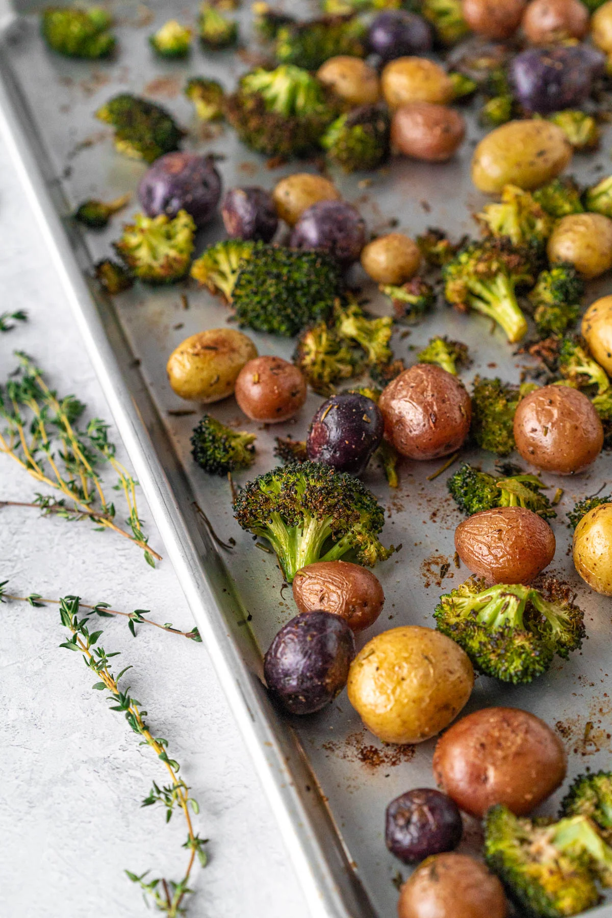 closeup shot of roasted potatoes and broccoli on a sheet pan