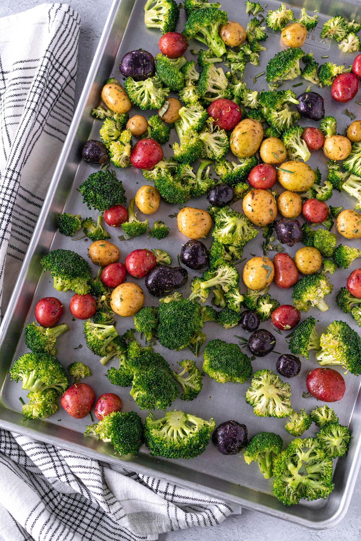 sheet pan with raw broccoli and potatoes