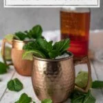 two copper mugs and a bottle of bourbon