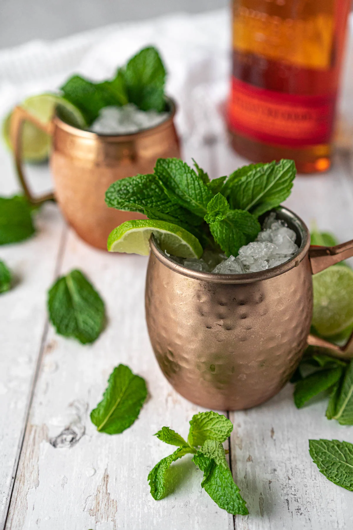 two copper mugs filled with bourbon mule