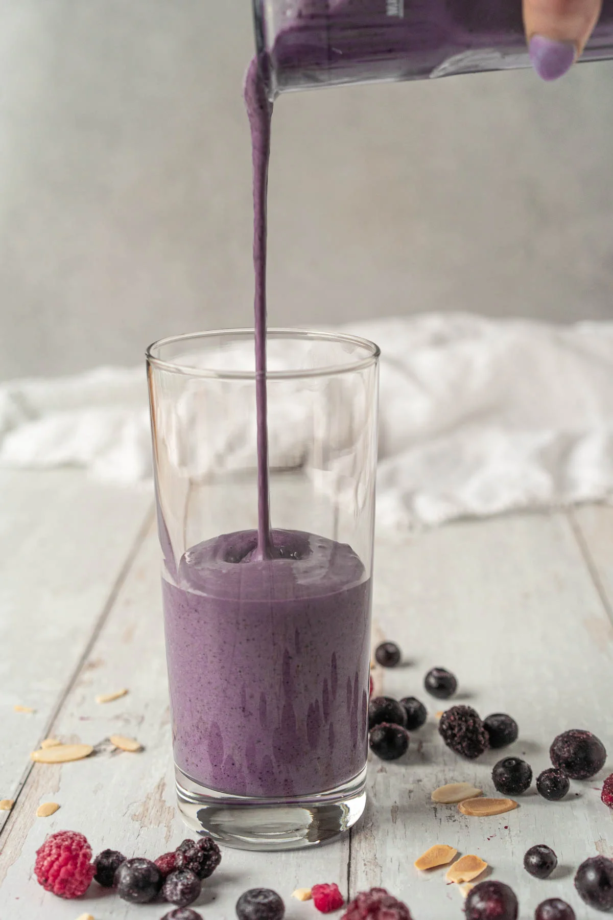 pouring purple shake into a glass