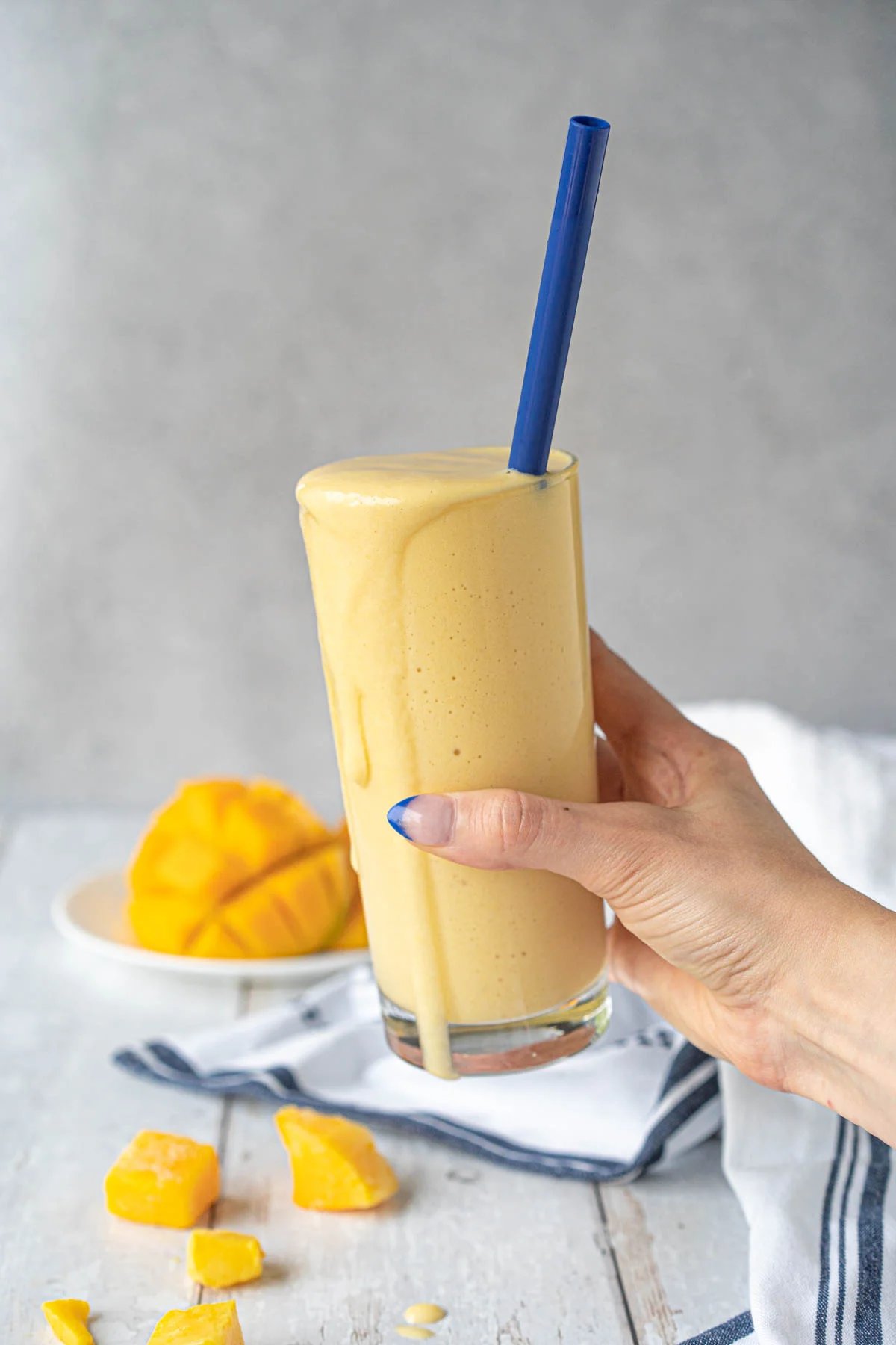 hand holding a yellow drink