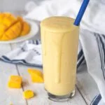 glass overflowing with a yellow smoothie