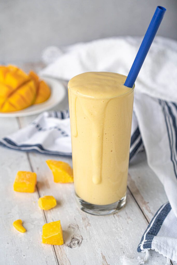 glass overflowing with a yellow smoothie