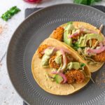 two shrimp tacos on a grey plate